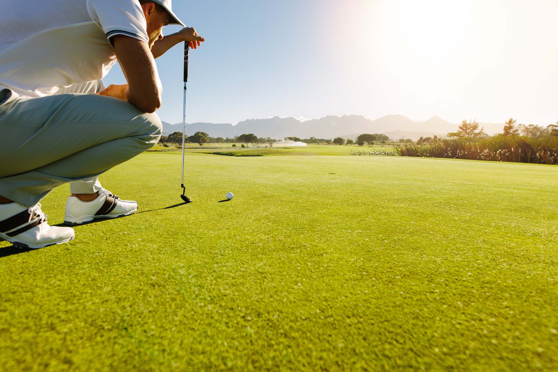 Golfer preparing a putt on a bright day, representing the clarity and ease made possible by organized tax planning and dependable accountancy services.