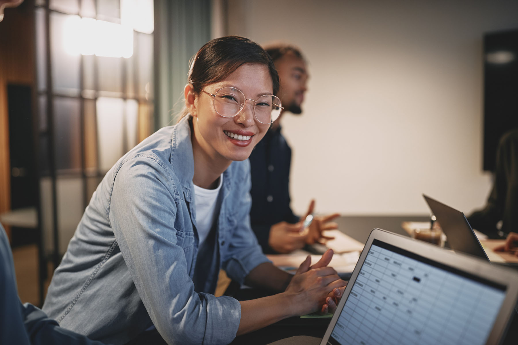 Professional woman smiling while working on a laptop with spreadsheets, representing organized tax documentation, accurate filings, and dependable accountancy support.