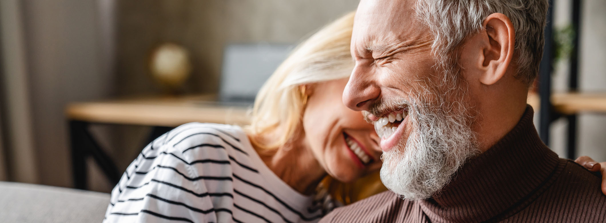 Older couple sharing a joyful moment at home, illustrating the comfort and peace of mind supported by accurate, dependable tax preparation and accountancy services.