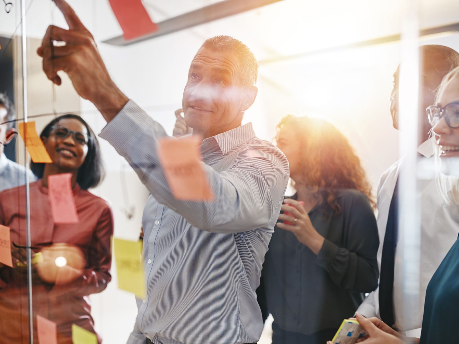 Team collaborating around a glass board with notes, representing organized processes and the collaborative approach behind thorough tax preparation and accountancy services.